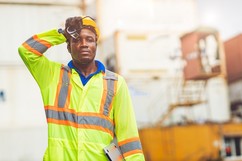 Worker in high visibility shirt wiping sweat
