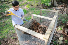 Man turning compost pile with pitchfork