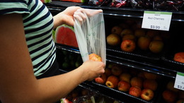 Person putting produce in grocery bag
