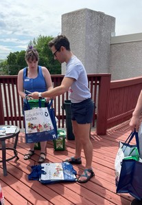 Residents distribute countertop organics bins and recycling collection bags