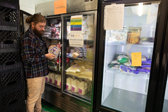 Person putting rescued food into a fridge funded by a waste prevention grant