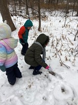 Kids play in the snow in the school forest