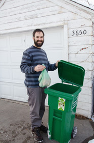 Man put bags of organics into green organics cart
