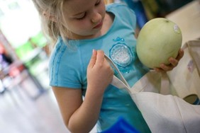 Girl with melon and reusable bag