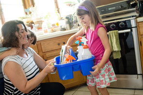 Mom and daughter with green cleaning supplies