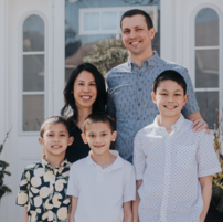 Photo of family of five standing outside house