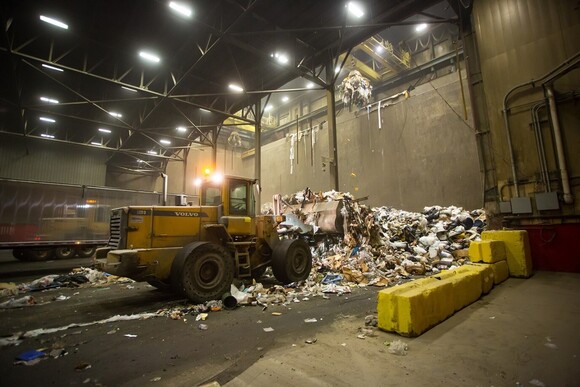 A front end loader pushing trash into the waste pit at HERC