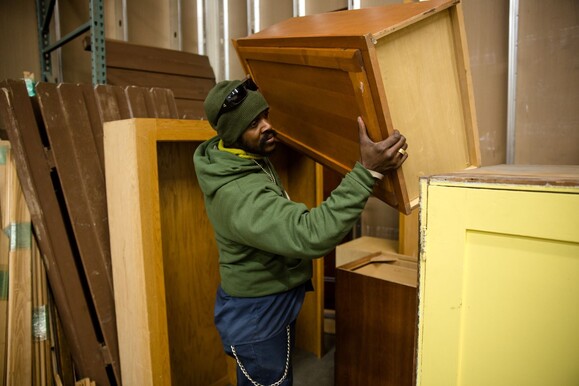 Man moving cabinets at a salvage warehouse