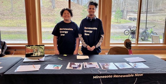 Two youth standing at a MN Renewable Now table