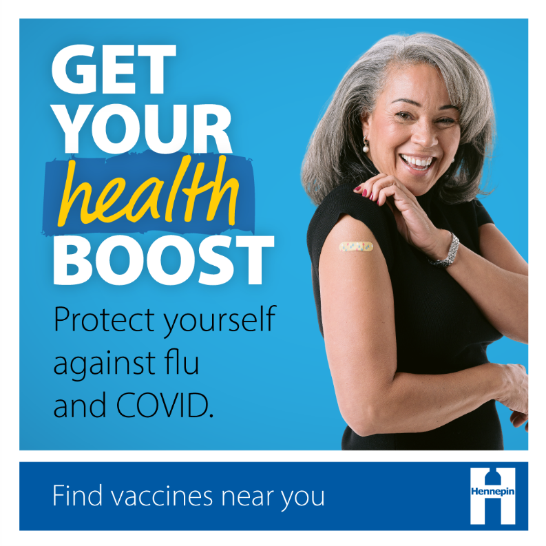 Woman with sleeve up showing Band-Aid on arm, post vaccination shot.