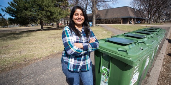 image of recycle ambassador standing next to recycling bins.