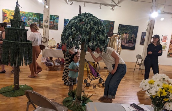 Child and adult look for bird cards in fabric trees at Art-a-Whirl