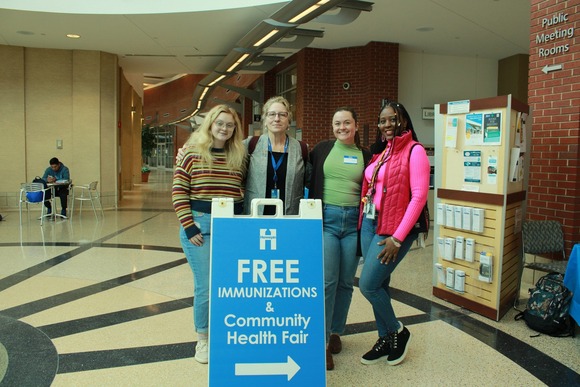 Four women standing at a vaccine awareness event