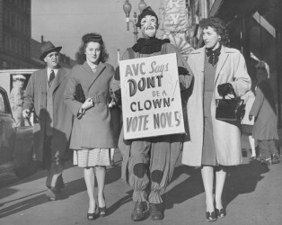 American Veterans Committee members parade in downtown Minneapolis with a clown and signs to remind citizens to vote in Tuesday's elections