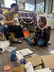 An Apartment Recycling Champion conducting an education session talking to a younger girl about if an item is recyclable