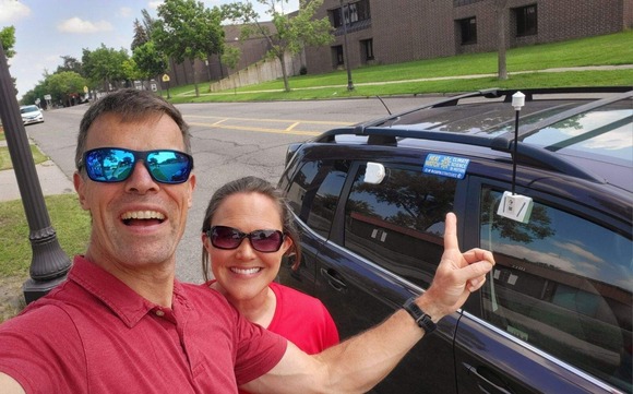 Volunteers outside car with heat sensor mounted on it