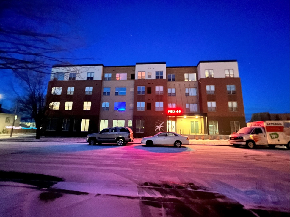 Apartment building with Vista 44 sign lit up at night