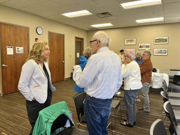 Heather stands next to a constituent, listening to concerns, at the Edina Library.