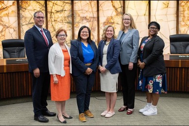 Commissioner Edelson poses with Cmsrs. Anderson, Goettel, Fernando, Greene, and Conley in the County Board room. All are smiling.