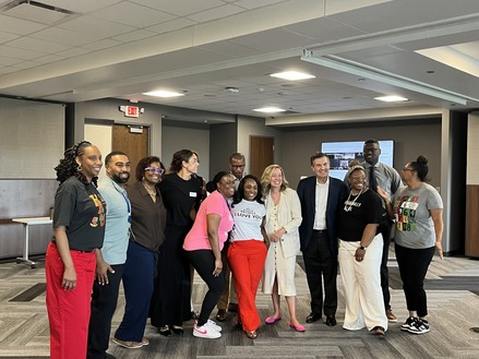 Heather poses with attendees of the Hennepin County ERG Juneteenth event; all are smiling.