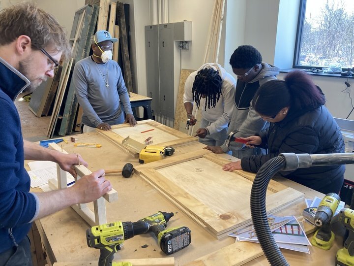 Participants building an aquaponics system with lumber