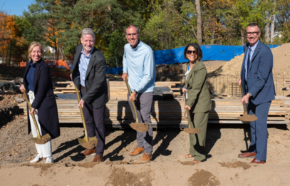Heather poses with four other county officials; they are all smiling and holding shovels as they "break ground."