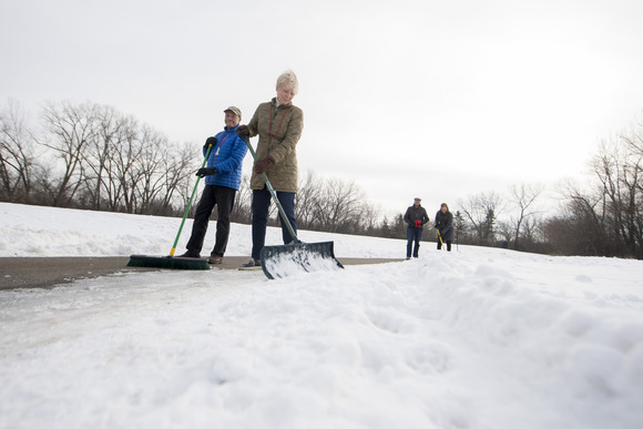 People shoveling and sweeping snow