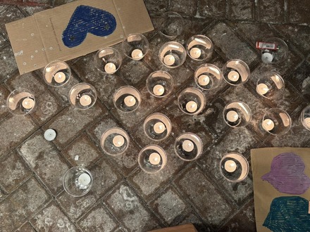 Photo of candles and cardboard with purple and blue hearts at 50th and France.
