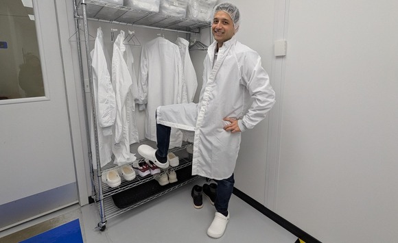 Person in a lab coat posing with reusable footware