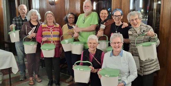 Group photo of people smiling with countertop organics bins
