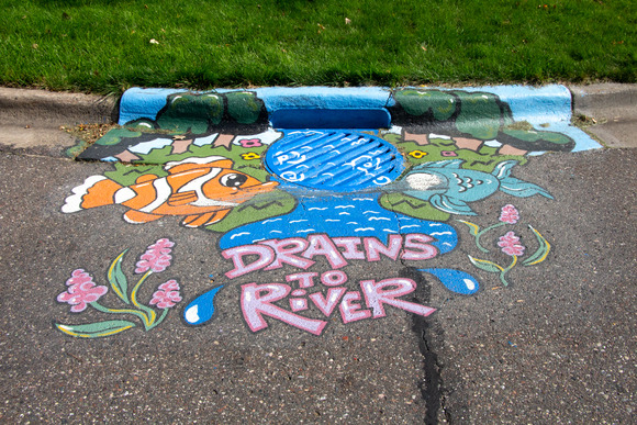 Storm drain mural with water and fish that says Drains to river