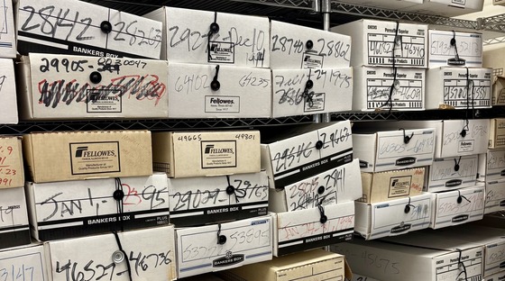 White archival boxes filling storage shelves