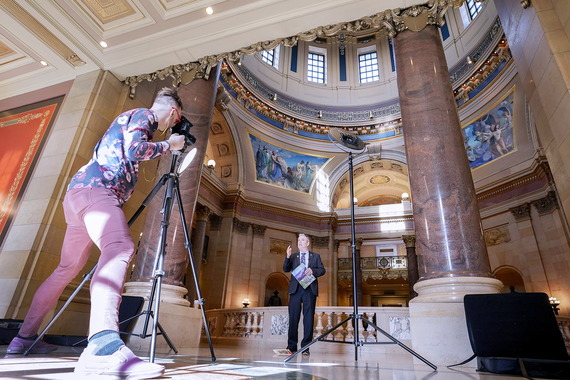 House member records a video message in a sunny Capitol Rotunda.