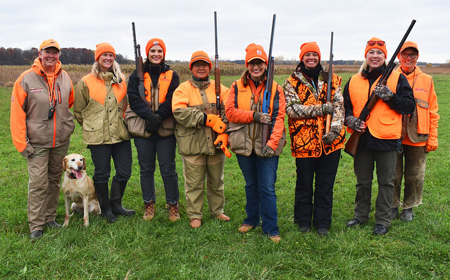 Group of hunters wearing blaze orange holding rifles