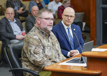 Man in camouflage at testifier table with Rep. Lislegard 