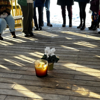 A candle and flowers in memory of Renee Good