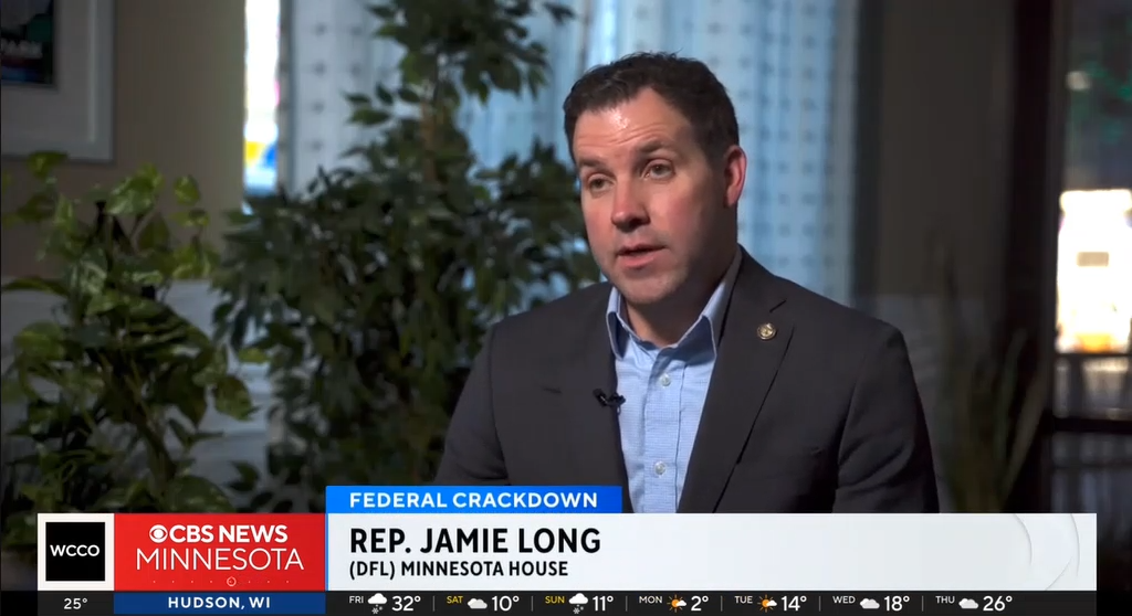 Rep. Long, seated, speaking to a reporter on WCCO TV
