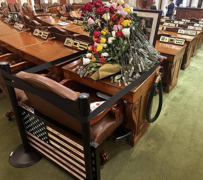 Melissa Hortman's desk on the House Floor, covered in flowers in memorial