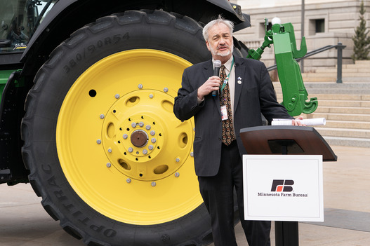 Rep. Hansen speaking in front of a big tractor