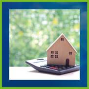 Small wooden house sitting on top of a calculator