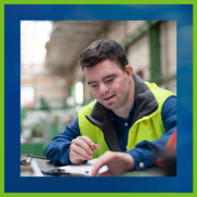 Man in bright green vest looking at a clipboard
