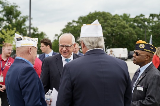 Minnesota Governor Tim Walz talks outside with three veterans in their military uniforms