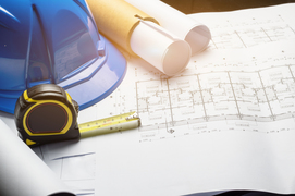 Hard hat, tape measure, blueprints 