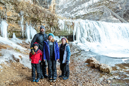 Father with three children in front of waterfall