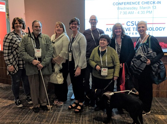 State of Minnesota employees at the CSUN Conference check-in. Jiffy the dog, in front.