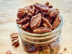 A jar or pecans with a light dusting of maple sugar crystals.