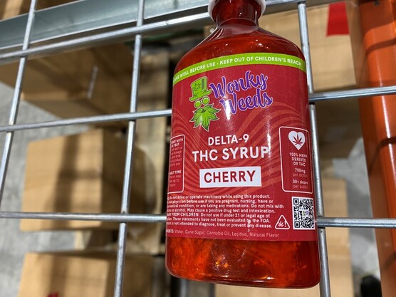 A bottle with the Wonky Weeds-brand cherry-flavored delta 9 THC syrup, with visible mold grown within the bottle.