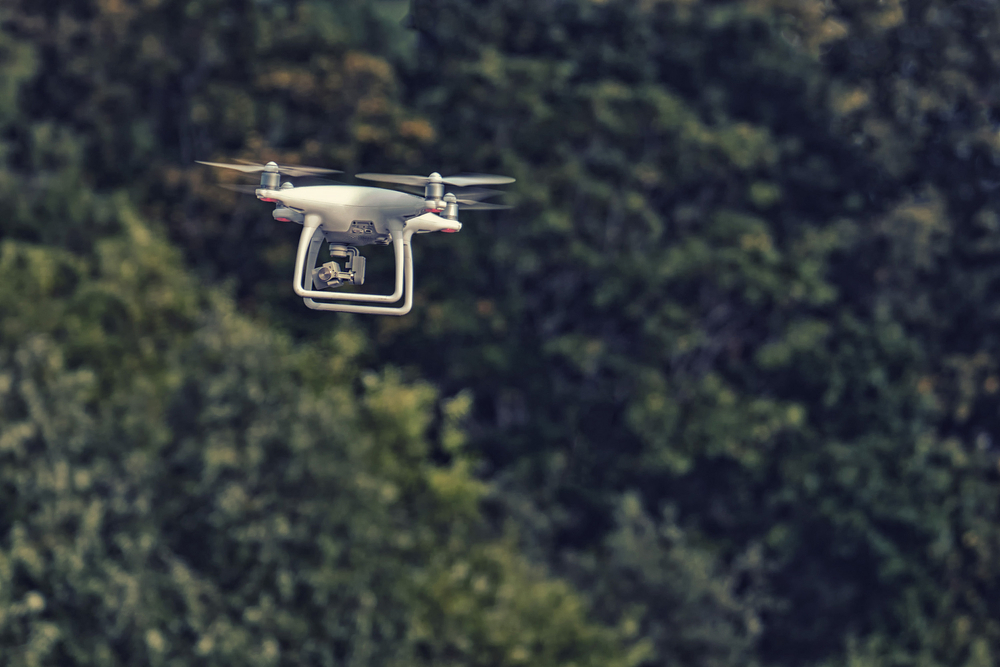 Drone flying above a dense forest