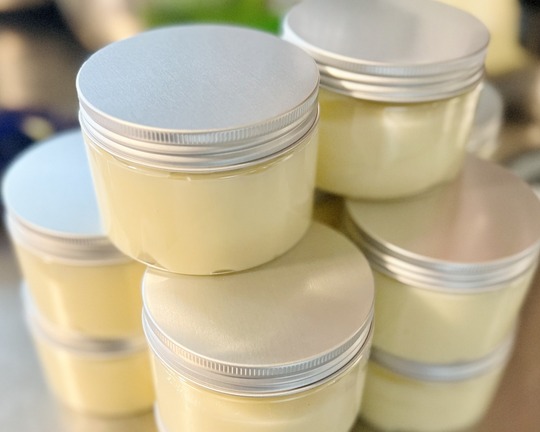 Small clear jars filled with a moisturizer made with whipped tallow.