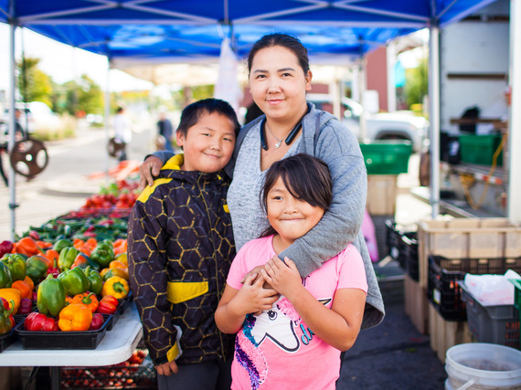 Mom and two kids at farmers market booth
